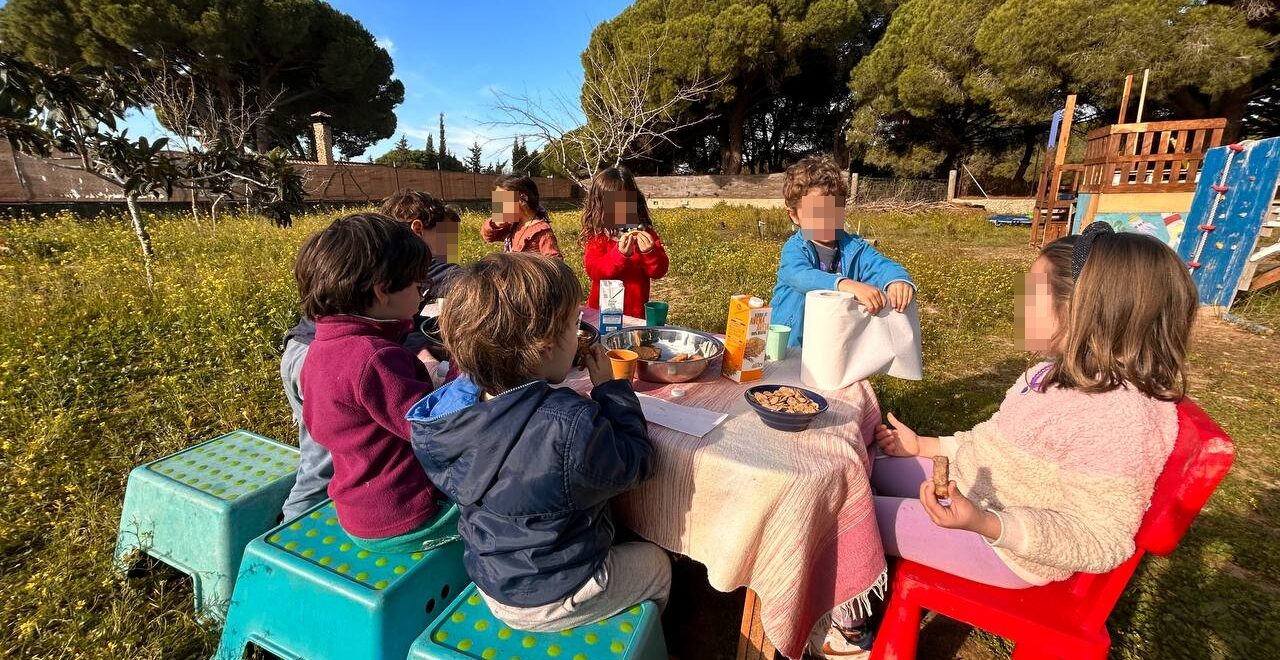 niños y niñas desayunando en el campo